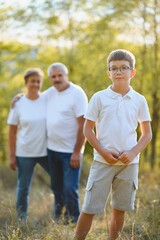 Fototapeta premium Grandparents and grandson together in autumn park