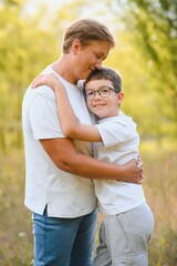 Obraz premium A beautiful grandmother spends time with her grandson in nature at sunset