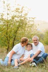 Grandfather grandmother and grandson having fun outdoors in park