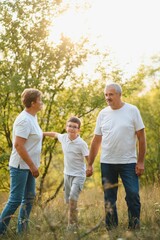 Grandparents and grandson together in autumn park