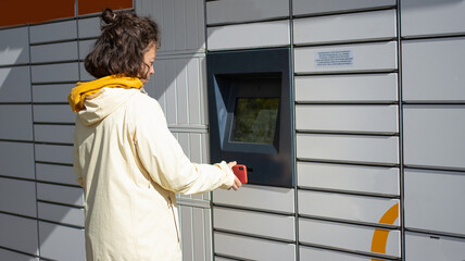 A person interacts with a digital kiosk in an urban setting, engaging with tech and services