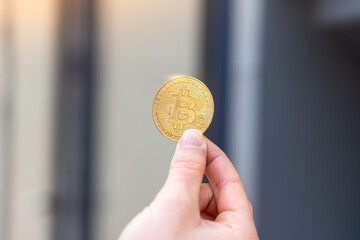 Young woman holding a Bitcoin at outdoors