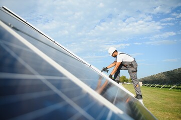 Naklejka premium Indian worker installing solar panels. Concept of alternative, renewable energy