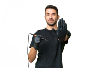 Tattoo artist caucasian man over isolated background making stop gesture