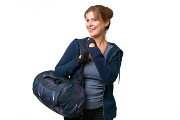 Middle-aged sport woman with sport bag over isolated background celebrating a victory