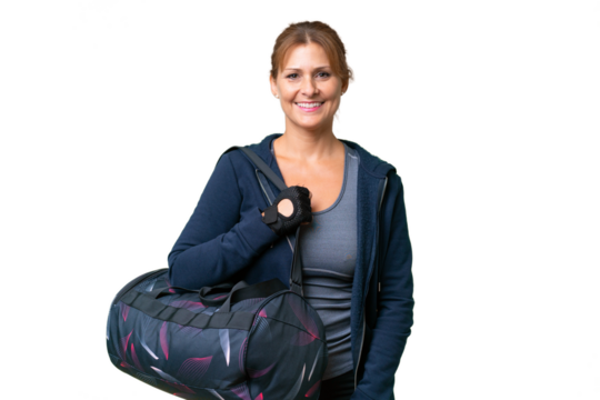 Middle-aged sport woman with sport bag over isolated background keeping the arms crossed in frontal position