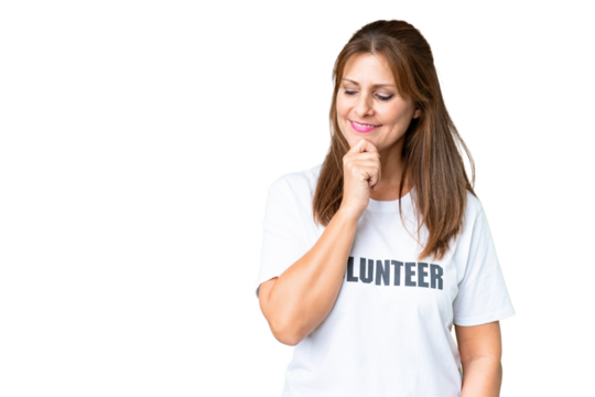 Middle age volunteer woman over isolated background looking to the side and smiling