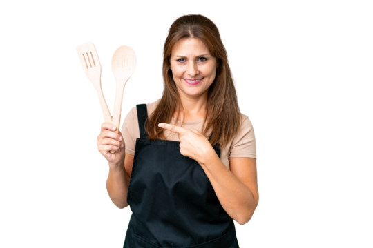 Middle age caucasian woman holding a rolling pin over isolated background pointing to the side to present a product