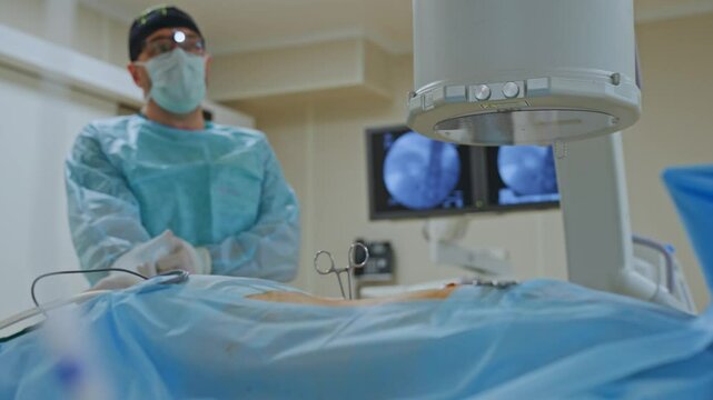 A surgeon removes fragments from a soldier's wound in the operating room