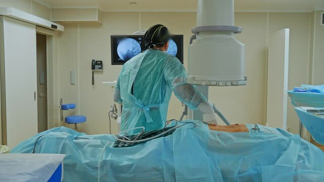A surgeon removes fragments from a soldier's wound in the operating room