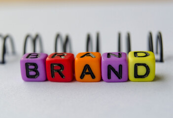 Close up of BRAND text representing on small square toy on white background