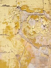 cracked yellow paint on stucco of old wall somewhere in france