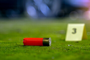 Bullet casings fell on the moss growing on the cement floor and blurry background of the evidence...
