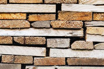 Wooden planks stacked on top of each other. Natural grain and pattern of the wood. Wooden material structure. Pile of boards made of wood. Forest industry.