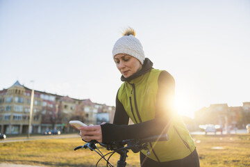 Woman Using Smartphone While Leaning on a Bicycle