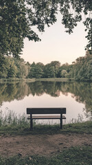 A solitary bench overlooking a tranquil lake, surrounded by lush greenery, invites contemplation and serenity.