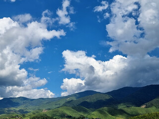 Fototapeta premium The perspective of the mountain range and nimbus clouds in the blue sky background