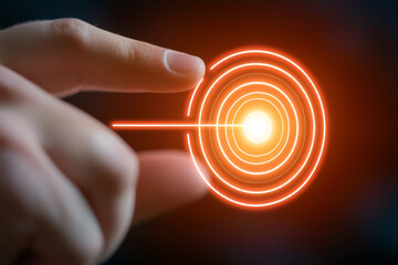 Fototapeta premium A hand reaches towards an illuminated target with concentric circles, symbolizing focus and precision in a digital environment.