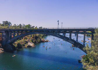 A wide shot of kids jumping off the Rainbow bridge in Folsom California.