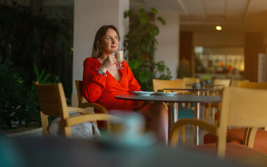 Girl in red dress drinking latte coffee.