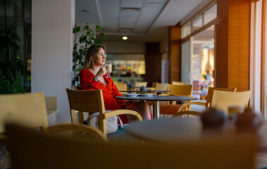 Girl in red dress drinking latte coffee.