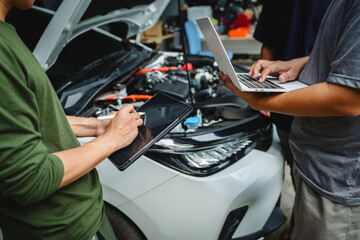 Naklejka premium Three Asian men discussing car insurance policies with adjuster. They review details such as premiums, deductibles, coverage options while handling recent claim and evaluating the settlement process.