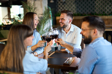Group of happy business colleagues toasting with wine in a restaurant