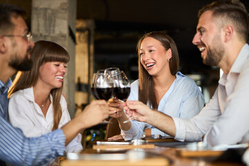 Group of happy business colleagues toasting with wine in a restaurant
