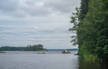 
High rocky shores above the water surface. There are mixed forests around.