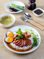 Barbecued red pork in sauce with rice on a white plate, Chinese style roasted pork.