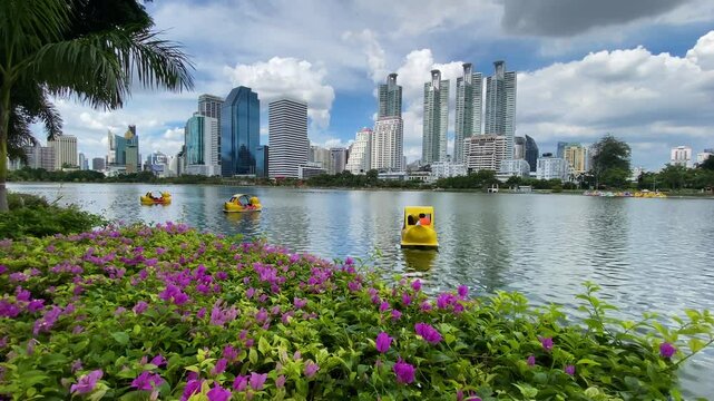 People ride a paddle boat in lake of Benjakitti Park, also known as Benchakitti, in Bangkok, Thailand. The park is located in the main business district of Thailand's capital.