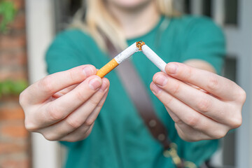 Breaking a Cigarette in Half. Smoking a broken Cigarette. Man and woman smoking a broken cigarette. Stop smoking. Quitting cigarettes.