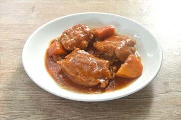boiled chicken tight with carrot in swet red gravy sauce stew on plate 