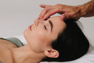 Post-surgery rhinoplasty care. Preventing swelling, deforming and additional complications with special nose band aid. Woman is having her nose taped after nose surgery.