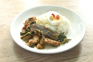 spicy str fried slice mackerel with chili and basil on rice topping boiled egg dressing chili garlic fish sauce in plate