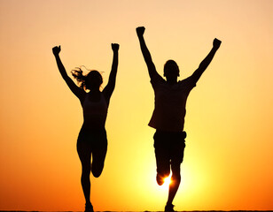 Silhouette of two people running with arms raised in the air. Sunset. Concepts of joy, success and celebration.