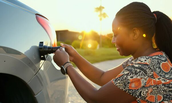 Botswanan Woman Teaching Car Oil Change to a Friend