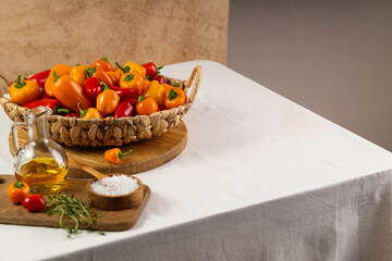 Natural locally grown colorful fresh bio mini bell pepper on wooden basket on light linen table cloth