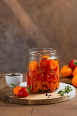 Probiotic foods. Eco friendly still life with pickled or fermented vegetables. Mini colorful bell pepper in glass jars on rustic wooden background . Home food preserving or canning