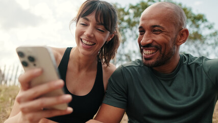 A man and a woman stare at a phone screen, cuddle and discuss social media content, scroll through...