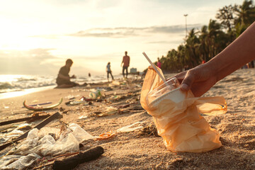 Volunteers are picking up plastic waste on the beach to reduce marine pollution, environmental...