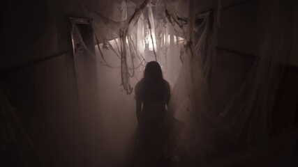 Ghost in abandoned house in the middle of cobweb. Horror scene of scary of young woman. Halloween