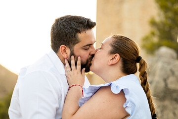Fototapeta premium A fat couple take some photos for a pre-wedding session in the surroundings of Jaén.The couple are kissing romantically.Concept of love between stuffed people.