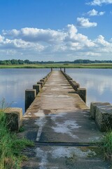 Fototapeta premium A bridge over a body of water with a cloudy sky in the background. The bridge is old and has a rustic appearance