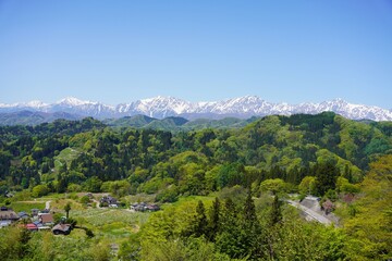 信州　小川村の風景　残雪の北アルプス新緑の里山