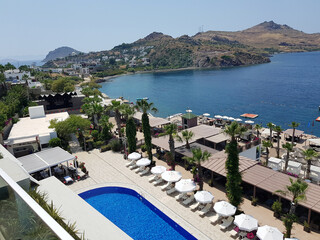 view of the pool and beach resort with sea and mountains on the horizon