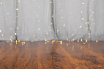 Wooden floor and gray curtains with garland in out of focus