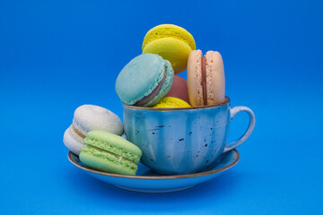 Colorful Macarons in a Blue Cup on a Vibrant Background