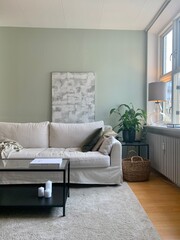 Danish livingroom with white sofa, green wall and art