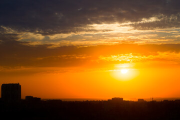 Sun in the Clouds over the Roofs of a Seaside Town